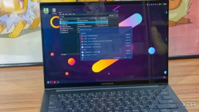 A close-up of an ASUS Zenbook laptop displaying a colorful abstract background and a file management window on the screen.