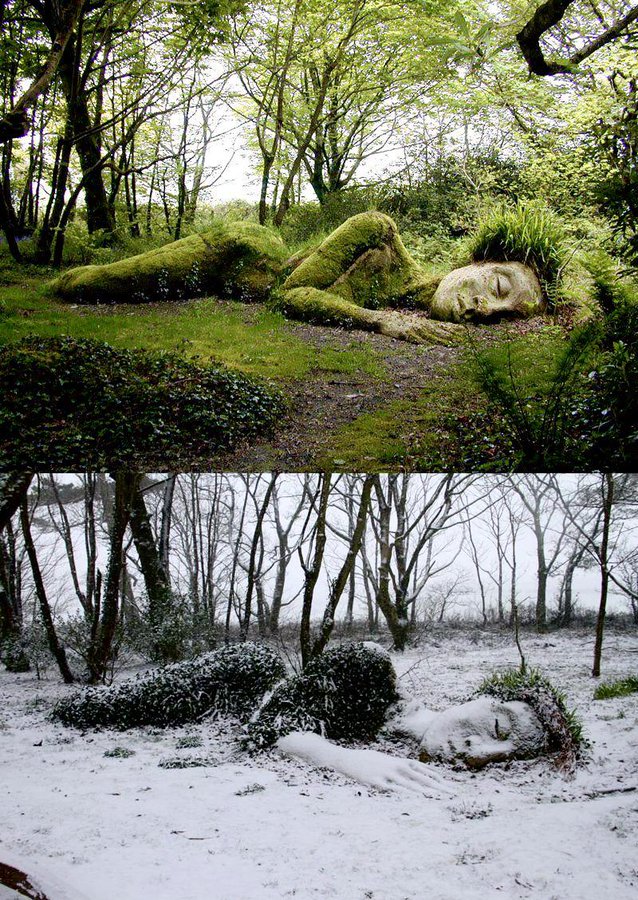 "The Mud Maid," a living sculpture by Sue Hill located in the Lost Gardens of Heligan, Cornwall, UK, depicting a reclining female figure partially covered with moss, grass, and seasonal plants. In the top image, the Mud Maid appears lush and green in the spring or summer, with vegetation resembling hair and a soft covering for her body. In the bottom image, the Mud Maid is blanketed in snow, her form serene and timeless, with her features softened by the winter landscape. The sculpture changes appearance throughout the year, echoing the transformation of the natural environment around her