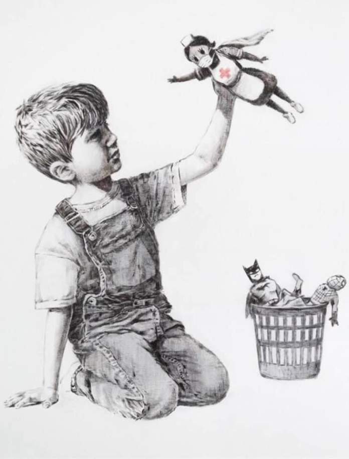 A Banksy artwork titled "Game Changer" showing a young boy kneeling on the floor, wearing overalls and a t-shirt, joyfully holding a toy nurse superhero in the air. The nurse wears a face mask, a cape, and a Red Cross emblem on her uniform, symbolizing healthcare workers as heroes. In a trash bin beside him, traditional superhero toys like Batman and Spider-Man lie discarded, highlighting a shift in societal values. The artwork is rendered in black and white, with the Red Cross emblem standing out in red.