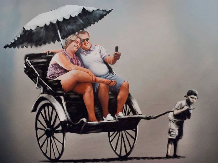 ‘Fat Tourist and Rickshaw’ from the Banksy vs. Bristol Museum exhibition at Bristol Museum, Bristol, 2009. This Banksy artwork portrays two overweight tourists sitting in a rickshaw, comfortably taking a selfie under the shade of an umbrella. The rickshaw is pulled by a young boy who appears strained, symbolizing exploitation and social inequality. The contrasting dynamic between the relaxed tourists and the struggling child offers a critique on privilege and the often overlooked labor of marginalized communities. Banksy’s stencil art style and choice of subdued colors enhance the impact of this thought-provoking scene.