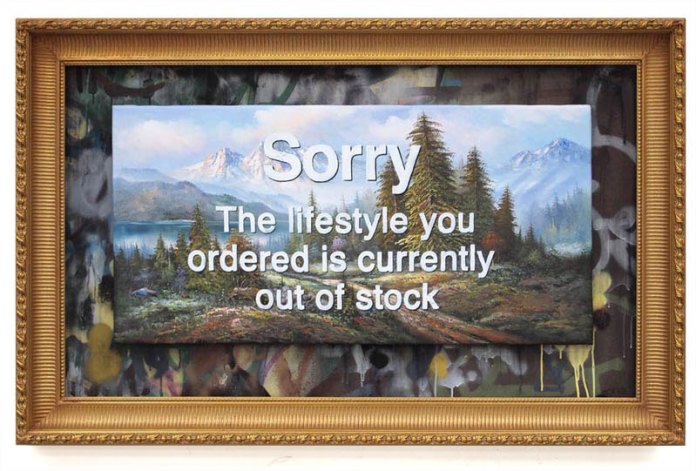 Artwork titled 'Sorry The Lifestyle You Ordered is Currently Out of Stock' by Banksy from 2012. The piece features a classic landscape painting with mountains, trees, and a serene lake in the background, overlaid with bold, white text reading, 'Sorry The Lifestyle You Ordered is Currently Out of Stock.' The artwork is framed in an ornate, vintage-style gold frame, contrasting with the modern, ironic message layered over the idyllic scene. The underlying landscape is painted in a traditional, tranquil style, while the phrase disrupts this peace with a commentary on consumer culture and unfulfilled expectations.