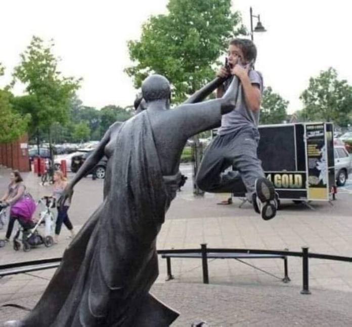Boy leaps with mouth open and eyes wide as a statue's arm aligns with his jaw, appearing to punch him midair.
