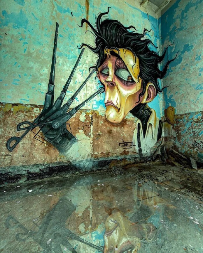Post-graffiti artwork by DavidL featuring Edward Scissorhands with his iconic scissor hands, painted on a distressed wall with a reflective puddle on the floor, located outside Barcelona, Spain.