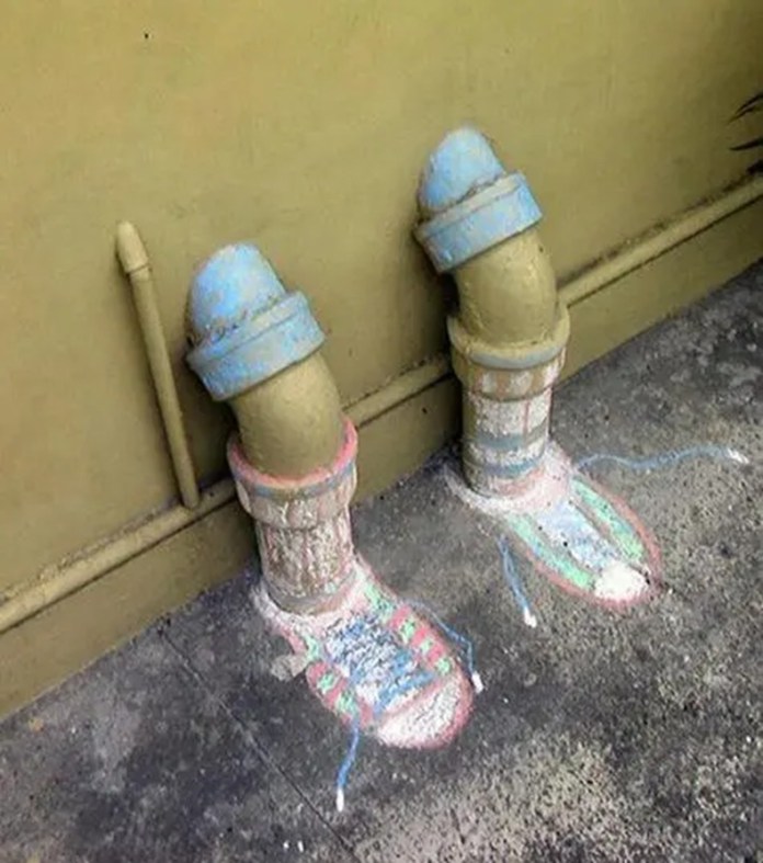 Two street pipes painted and designed to look like legs with shoes and socks.