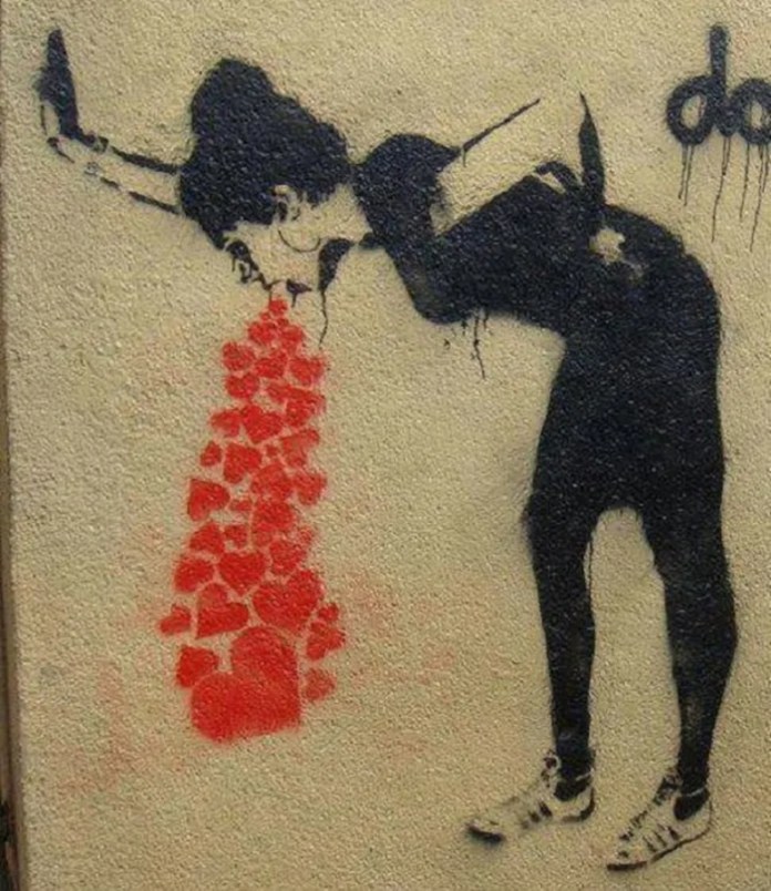 A street stencil by an anonymous artist in Germany showing a woman in black clothing, bent over and vomiting a stream of red hearts onto the ground. She holds a smartphone in one hand, blending themes of love, modernity, and emotional overload.