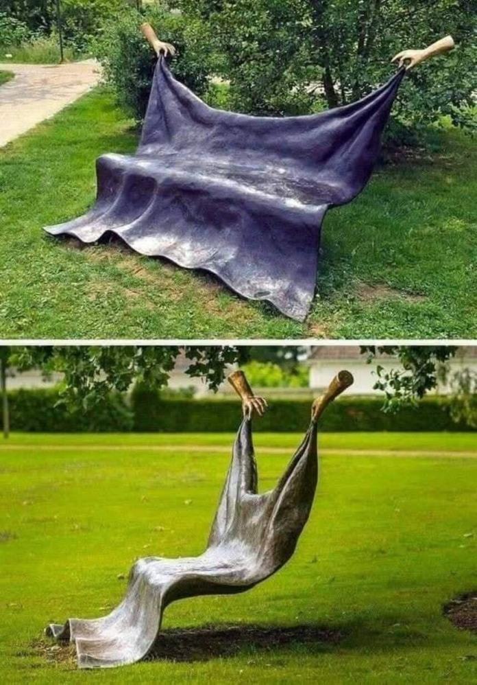 Two public sculptures showing bronze cloth held by hands—one forming a bench, the other suspended like a hammock—in a grassy park setting.