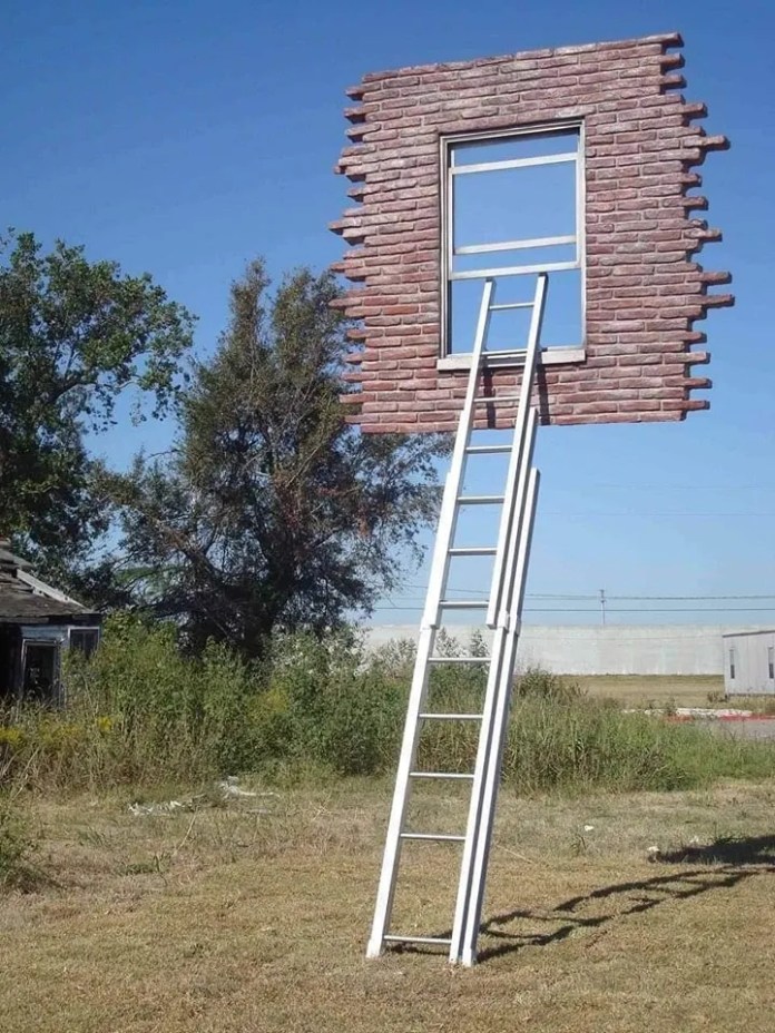 Surreal sculpture in Montevideo, Uruguay by Leandro Erlich showing a suspended brick wall with a window, held up by a white ladder standing in grass. The structure floats with no visible support beyond the ladder.