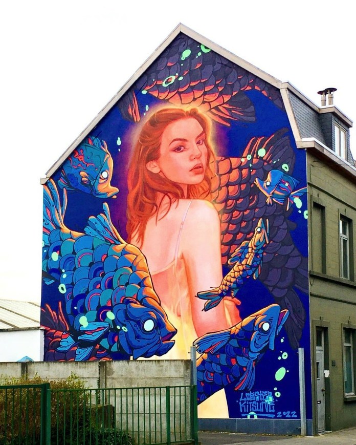 Mural of a woman in a light dress surrounded by large glowing blue koi fish against a dark navy background, painted by Kitsune and Lobster Robin in Ghent, Belgium.