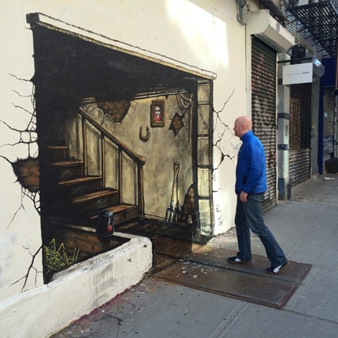 Wall mural titled “Basement Underworld” showing a broken wall opening to a dimly lit basement with old stairs, tools, a horseshoe, cracked surfaces, and framed portrait on the far wall.