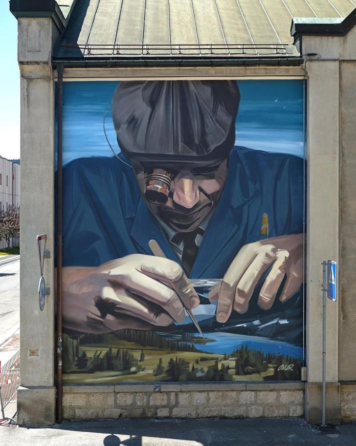 A mural of a man in a cap working with watchmaking tools. He appears to be repairing a clock, but the mechanism transforms into a detailed landscape of lakes and trees.
