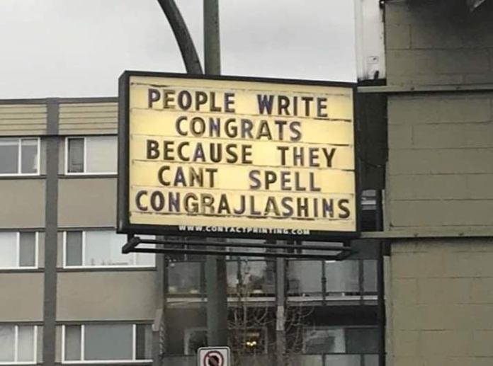 A reader board sign outside a business reads “PEOPLE WRITE CONGRATS BECAUSE THEY CAN’T SPELL CONGRAJLASHINS” in blocky uppercase letters.