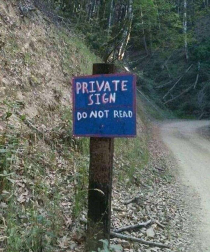 A wooden sign on a trail reads “PRIVATE SIGN. DO NOT READ” in all caps, creating an amusing contradiction.