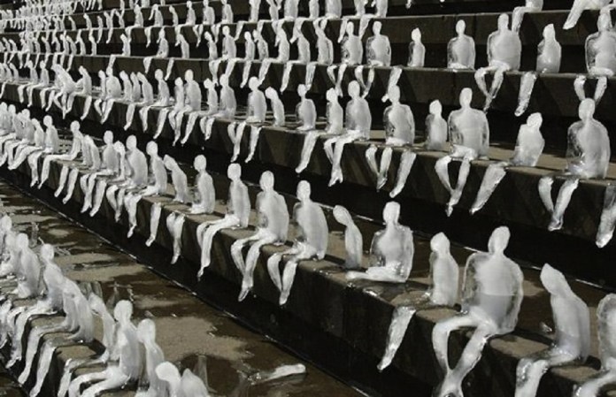 A striking installation titled "Melting Men" by artist Néle Azevedo, showcasing hundreds of small, human-shaped ice sculptures placed on outdoor steps. As the ice figures slowly melt under the sun, the artwork symbolizes the fragility of humanity and the urgent need to address global warming and climate change. The ephemeral nature of the piece emphasizes the fleeting impact of human existence and serves as a poignant call to environmental action. The contrast between the orderly placement of the figures and their inevitable demise creates a haunting visual metaphor for our collective responsibility.