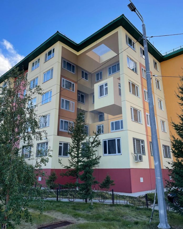 Anamorphic mural by Shozy in Salekhard, Russia, showing a surreal geometric illusion with window boxes that appear to float or recede into a void in the center of the building.