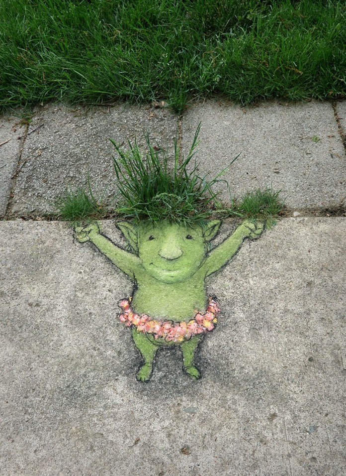 Sidewalk art in Ann Arbor of a small green character with grass for hair and a flower skirt, created using paint and natural growth.