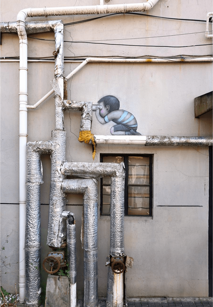 Street art by Seth Globepainter in Shanghai, China, depicting a small child crouching and peering through silver pipes, which resemble a periscope. The child is painted directly above a real window and pipe system.
