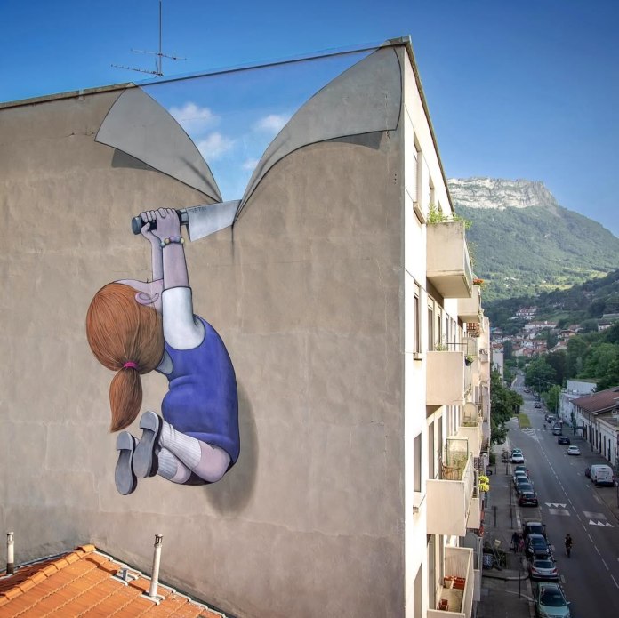 Mural by Seth Globepainter in Grenoble, France, showing a girl with red hair hanging from a painted tear in a gray wall, revealing a patch of blue sky beyond. She grips a large knife to slice through the concrete-like surface.