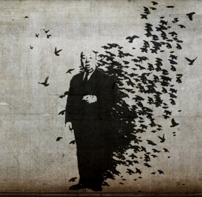 A stencil mural of Alfred Hitchcock standing in a suit, with his silhouette breaking apart into a chaotic swarm of black birds flying away.