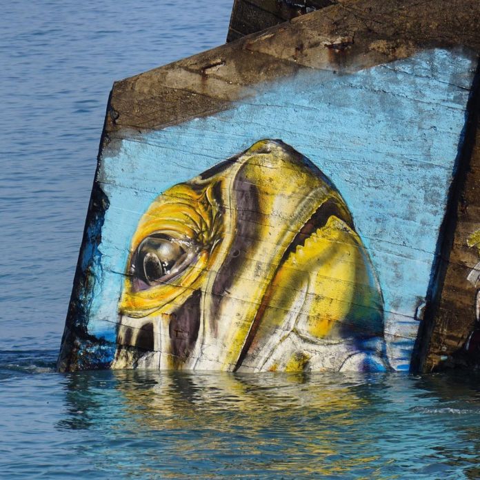 Graffiti mural by Näutil of a turtle at a beach