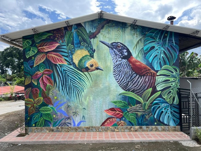 Rear wall mural of a tanager bird flying toward a perched striped bird amid large tropical leaves and glowing forest textures, creating a nighttime jungle atmosphere.