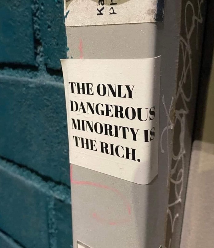 Sticker with a provocative political statement about wealth and inequality, reading ‘The only dangerous minority is the rich.
