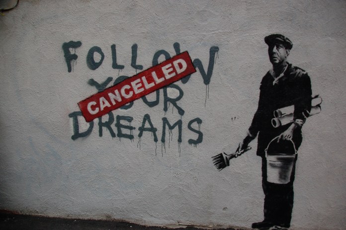 Mural showing a man in painter's uniform holding a brush and bucket next to the words “Follow Your Dreams” stamped with “CANCELLED” in red. Drips from the paint make it look fresh.