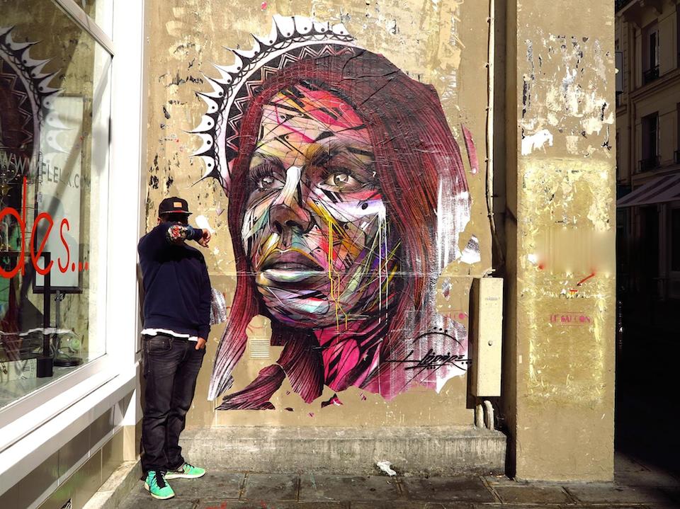 A mural by Hopare in Paris, France, showing a portrait built from energetic colored lines and geometric forms.