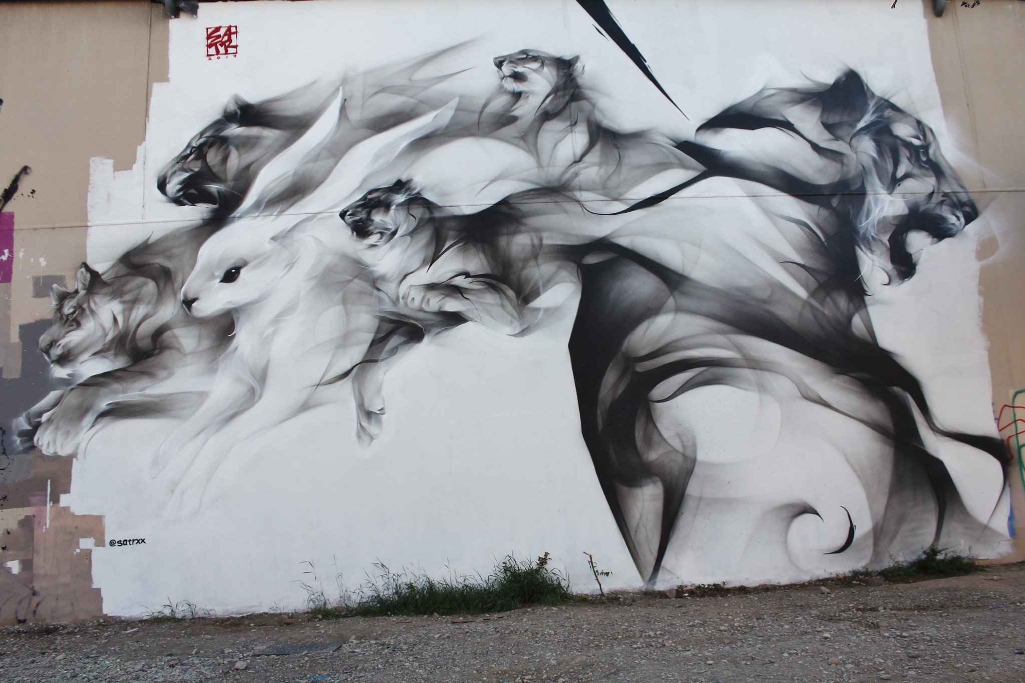 A mural by SATR, also known as SatrXX, in Lyon, France, showing smoky black and white animal forms moving across a large wall.