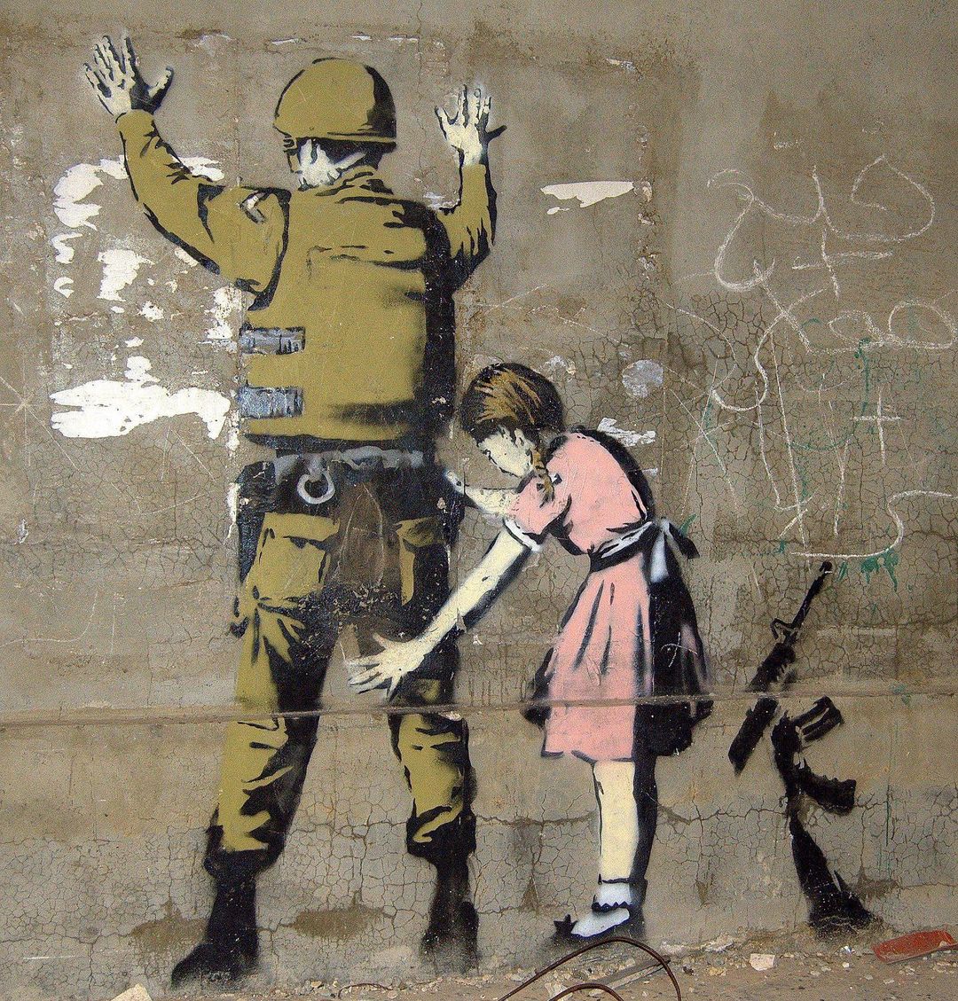 Young girl frisking a soldier by Banksy in Bethlehem.