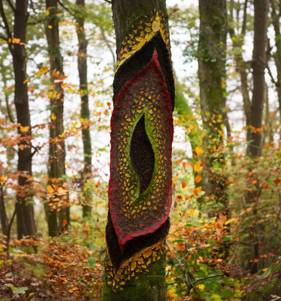 Orange leaves spiraling up a tree trunk and extending outward in a circular pattern.