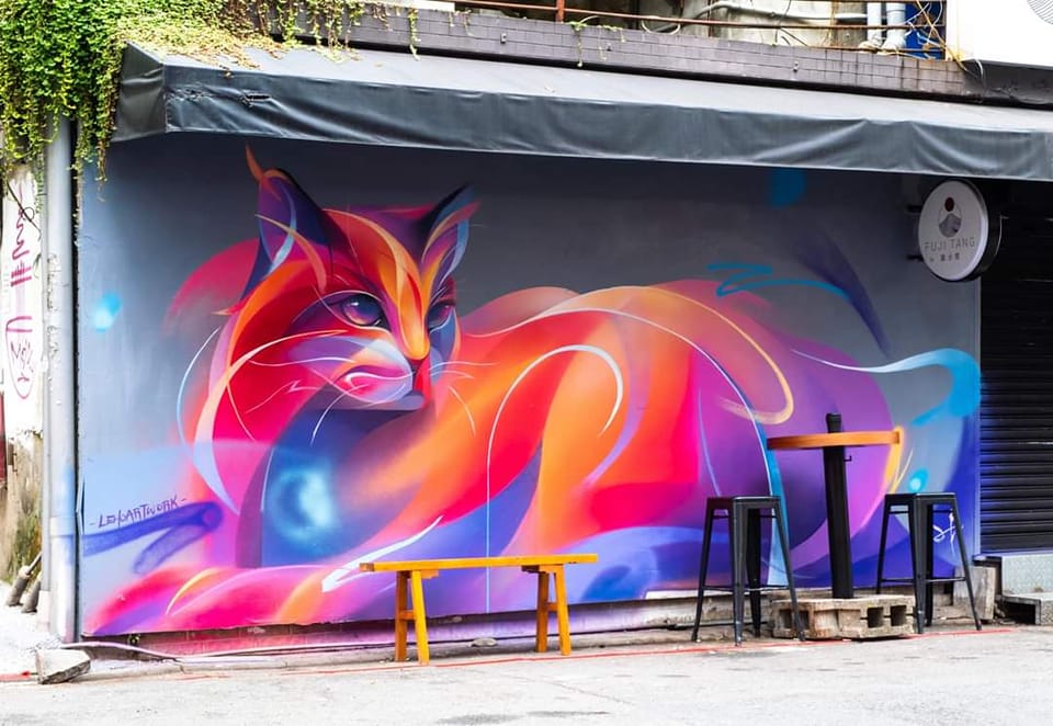 A glowing red 3D illusion street art mural of a cat by LeHo Artwork in Taipei, Taiwan.