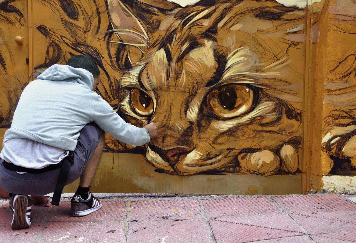 A unique, elongated graffiti character mural of a stylized cat by street artist Stamatis Laskos in Naousa, Imathia, Greece.