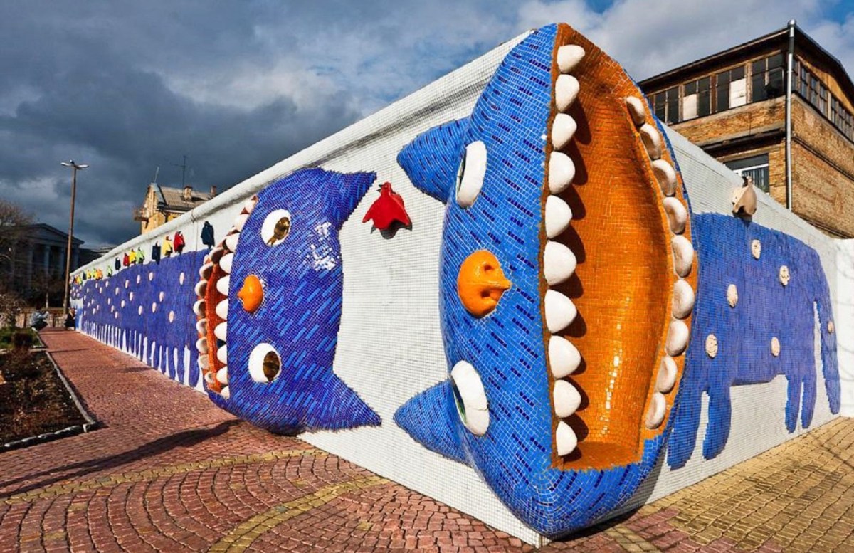 A whimsical and colorful mosaic street art sculpture of a smiling cat by K. Skretutsky in Kyiv, Ukraine.