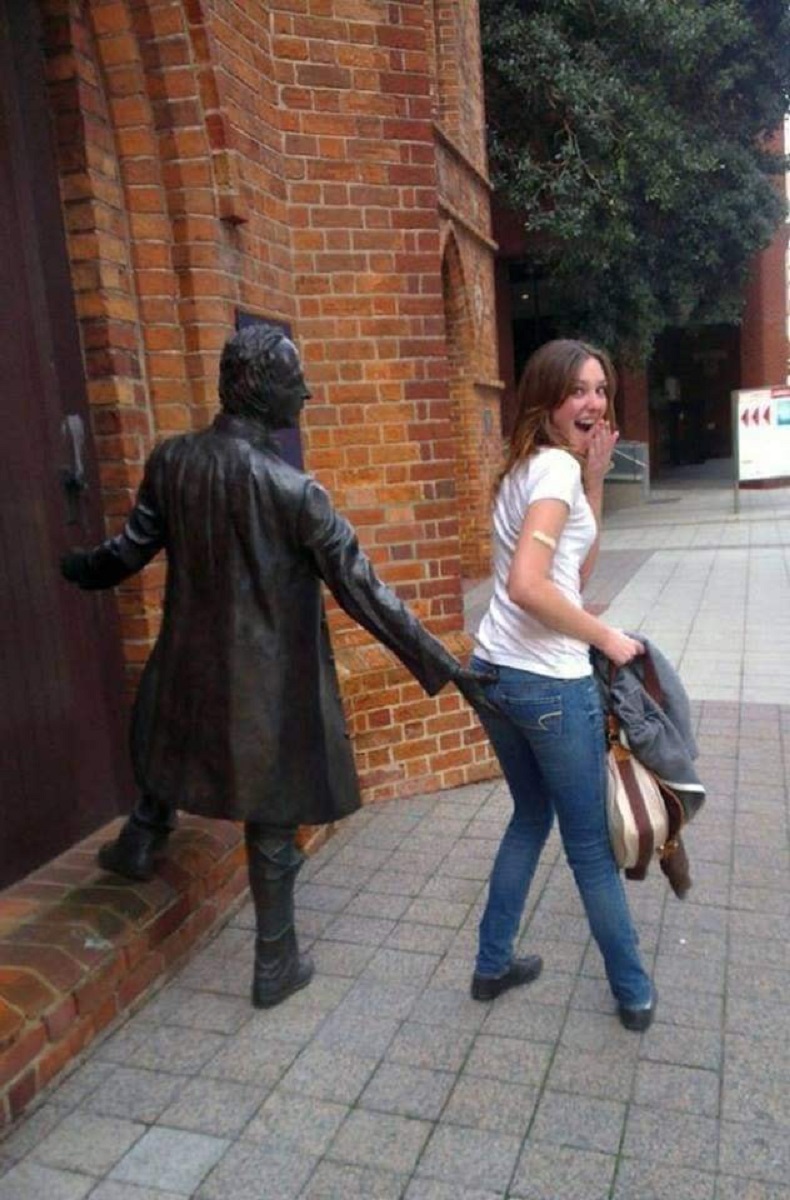 Hilarious forced perspective street art where a bronze statue seems to touch a shocked woman. This interactive 3D illusion takes public mural art to a funny new level.