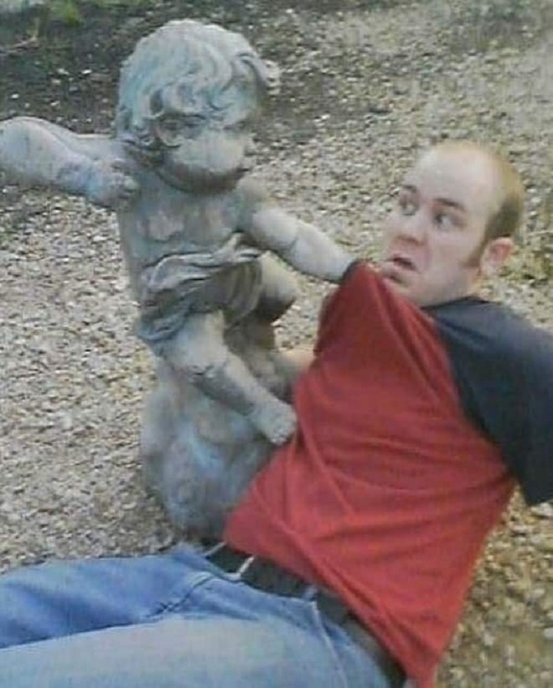 Hilarious museum street art interaction. A classic cherub marble statue appears to attack a guest in this clever 3D illusion and public graffiti moment.