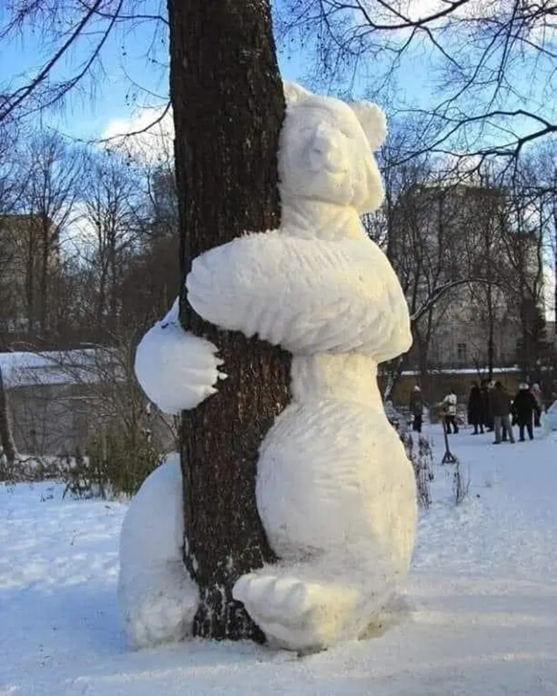 Snow bear hugging a tree