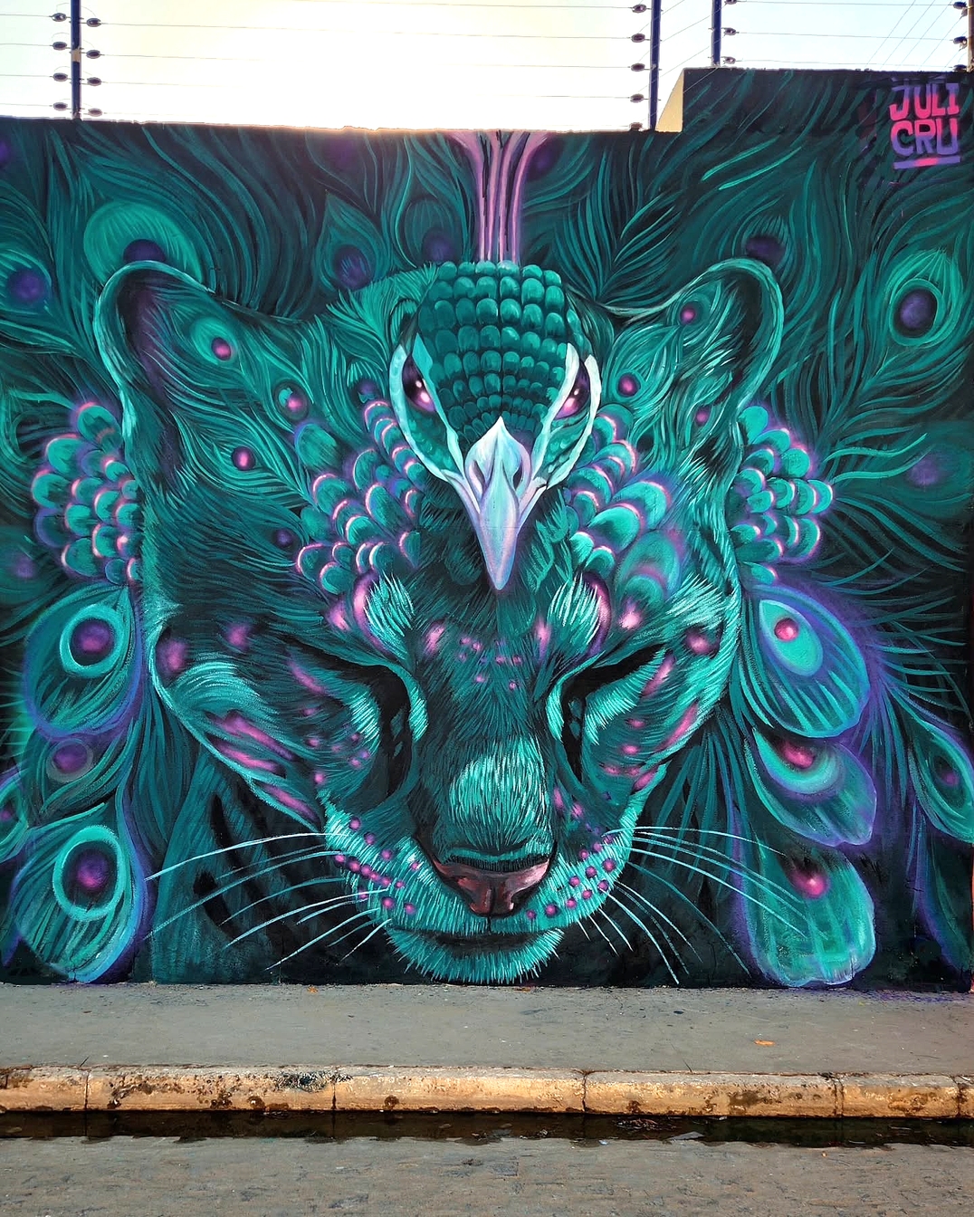 La Selva en carnaval by Julián Cruz Solano in Petrolina, Brazil, showing a surreal jaguar face blended with teal and purple peacock feathers.