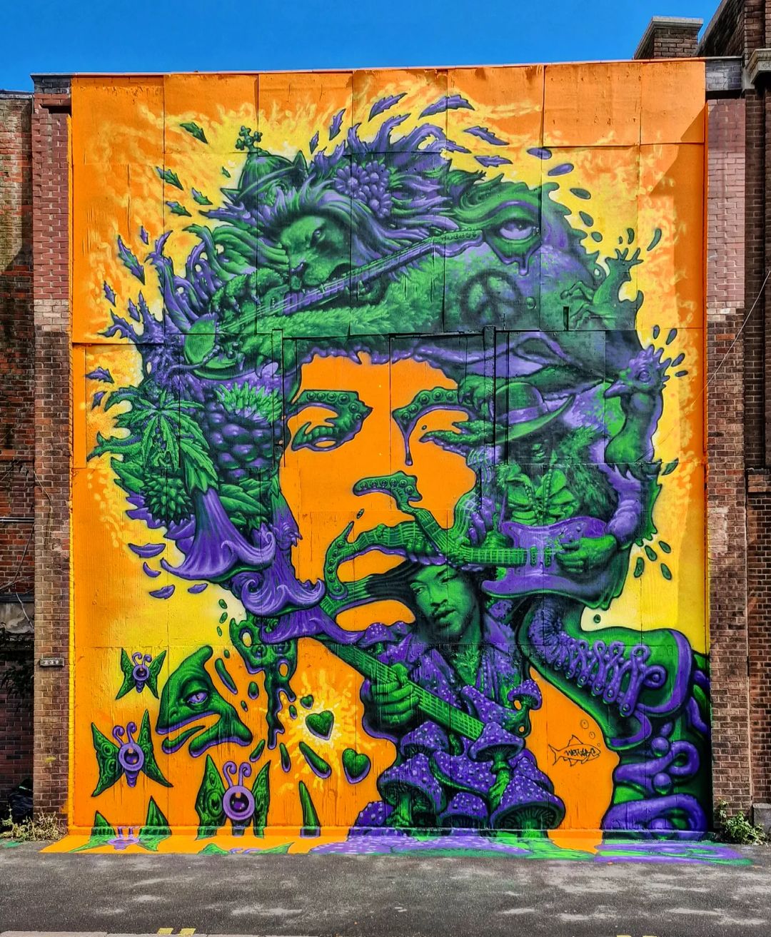 Psychedelic tribute mural of Jimi Hendrix with vivid green, purple, and orange tones.