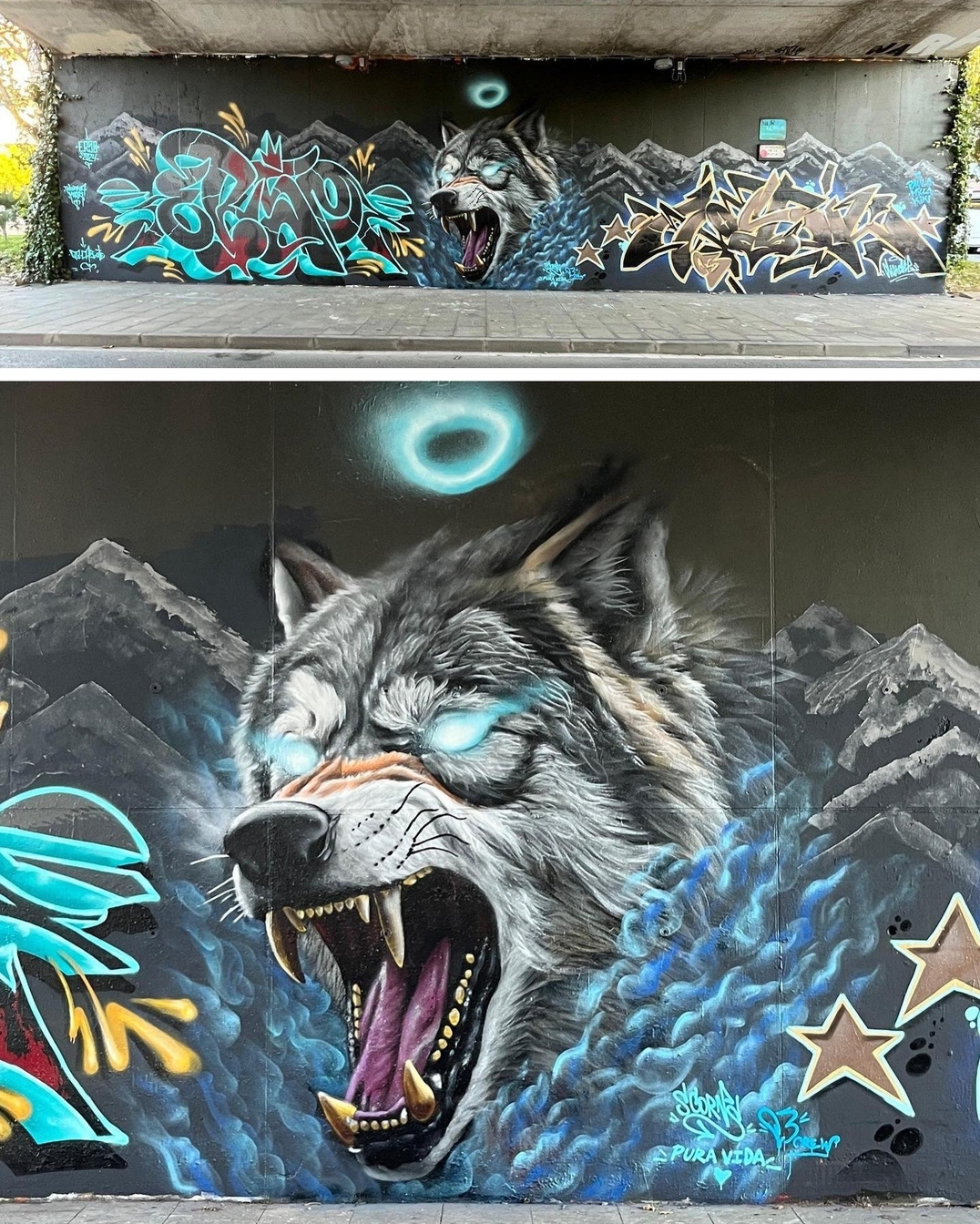 A mural under a bridge in Castelldefels, Spain, featuring a snarling wolf with glowing blue eyes and sharp fangs, surrounded by mist-like energy. The artwork blends with intricate graffiti lettering on both sides and a backdrop of dark mountains under a night sky with a glowing blue halo. The wolf's fur is meticulously detailed, giving it a strikingly realistic yet mythical appearance.