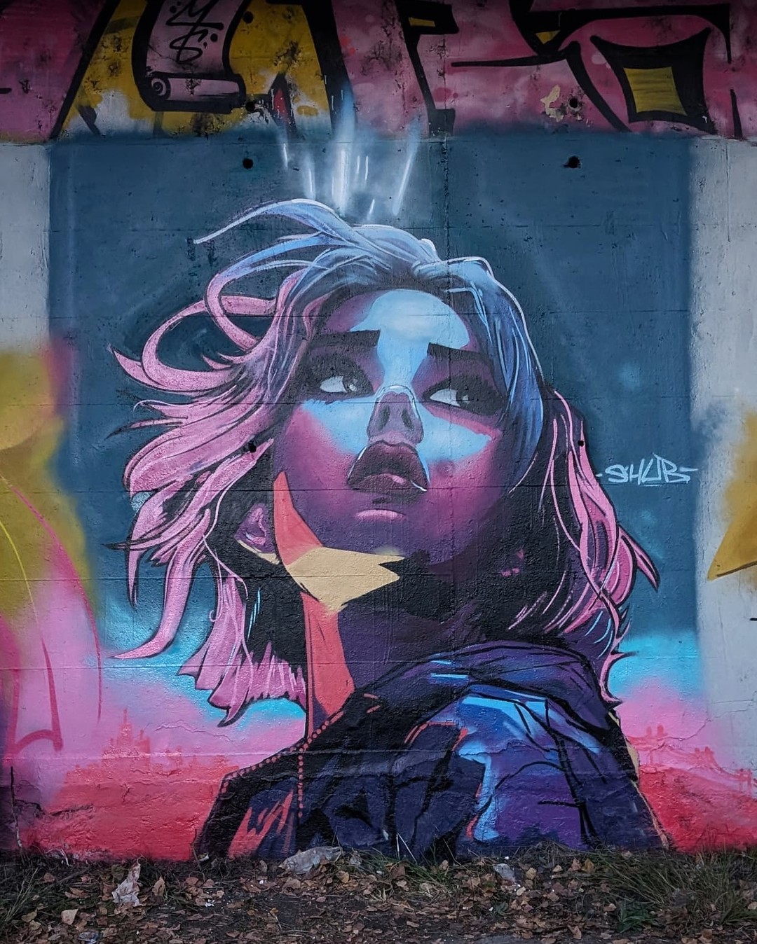 A vibrant mural by Shub_110 featuring a neon-lit portrait of a woman gazing upward, her expression filled with wonder and intensity. The artwork is painted in electric shades of pink, blue, and purple, with glowing light streaks emerging from her head, adding an ethereal, futuristic feel. The background blends abstract elements with a deep cosmic aura, making the portrait feel almost otherworldly.