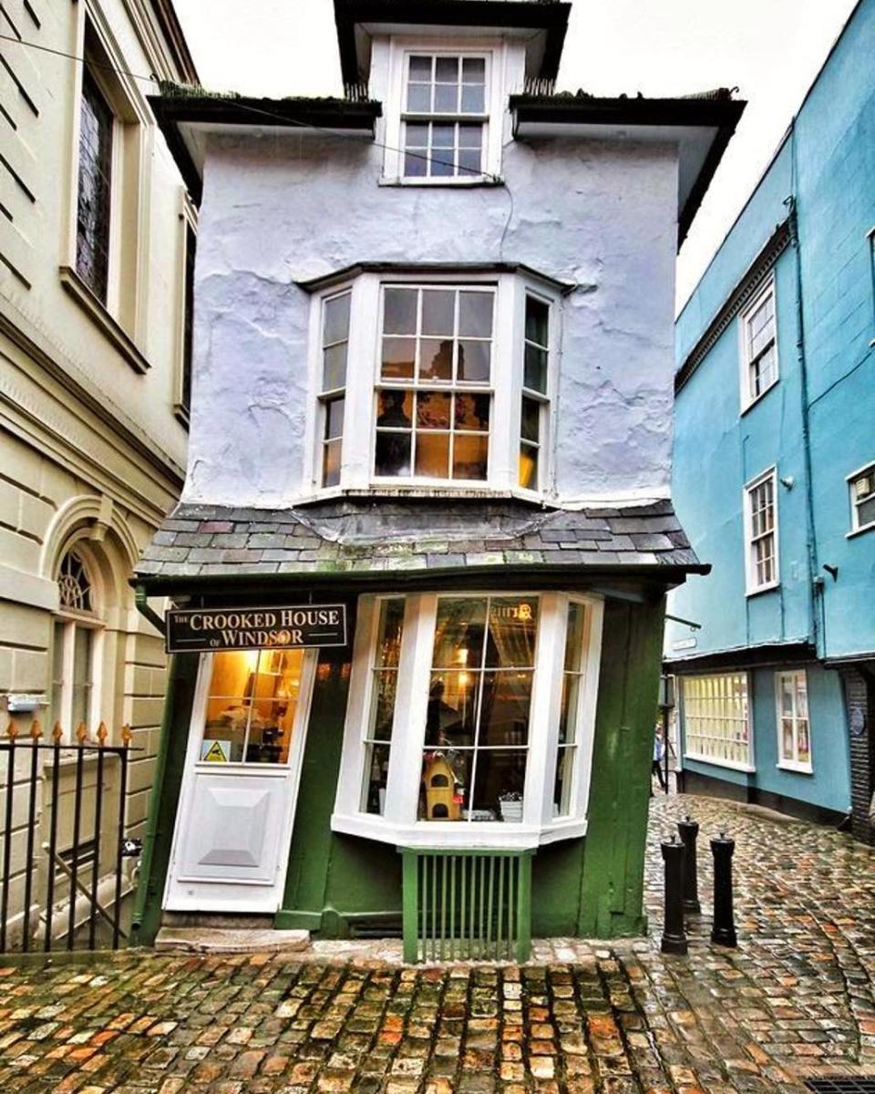 The Crooked House of Windsor, a leaning black-and-white timbered building with a tilted facade in Windsor, England.