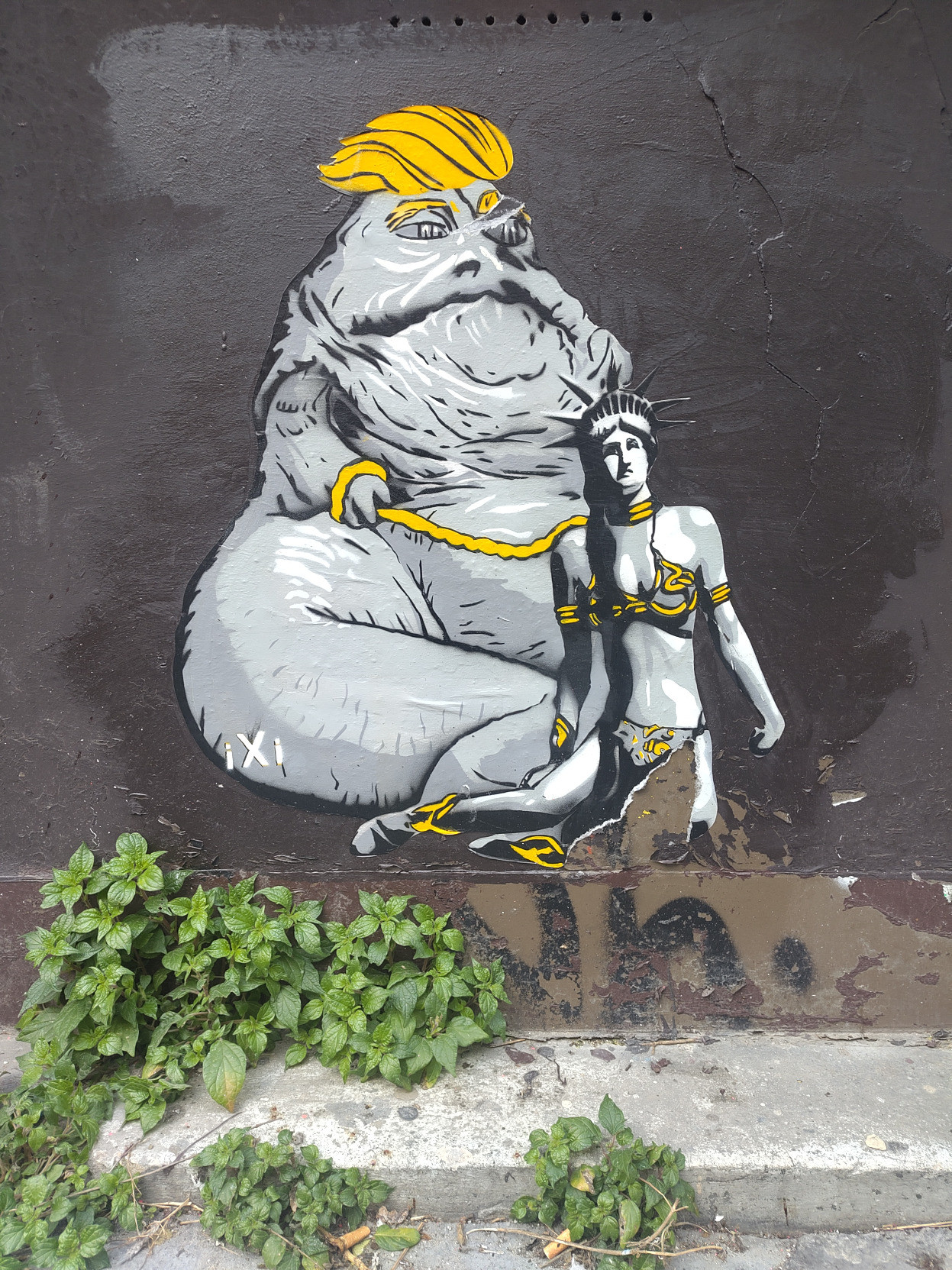Satirical Star Wars-inspired mural in Paris, France, showing a yellow-haired Jabba-like figure holding a chained Statue of Liberty figure dressed like Princess Leia. Photo by Robert Pickering.