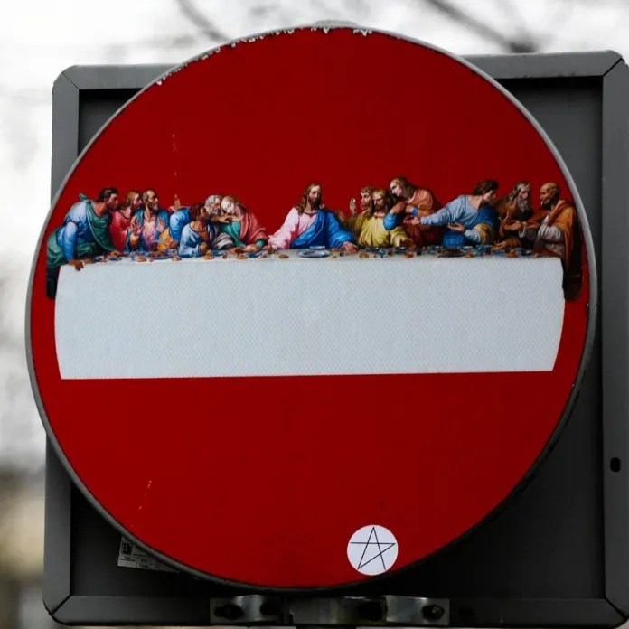 AxZstreetart's Warsaw intervention turning a no-entry sign into a small version of The Last Supper.