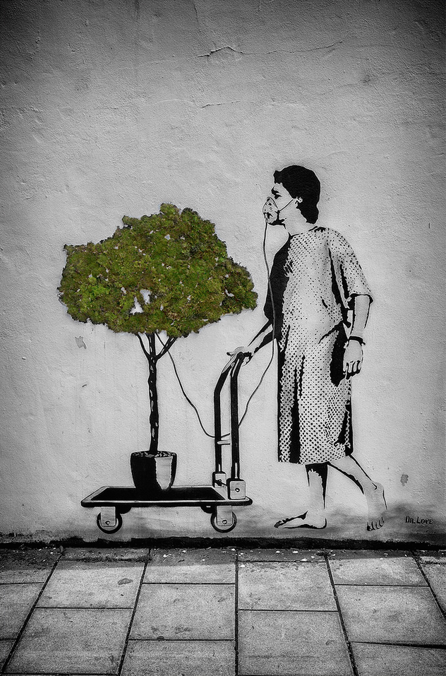 Dr Love stencil in Bristol showing a woman breathing from a tree on wheels whose crown is made of real moss.
