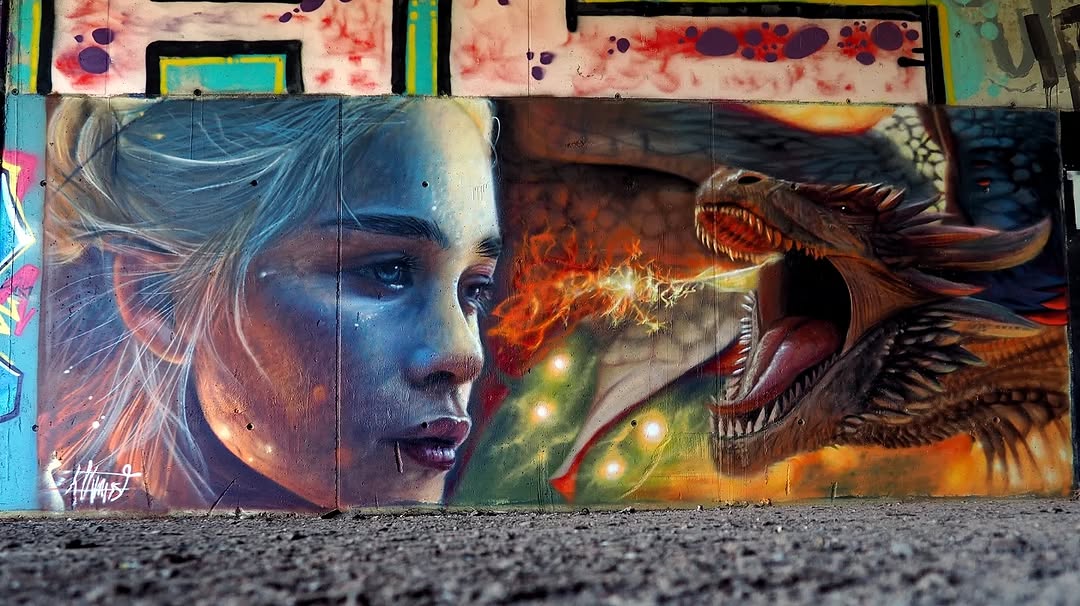 Wall mural showing Daenerys from Game of Thrones staring at a fire-breathing dragon, painted in photorealistic detail with glowing flames and textured dragon scales.