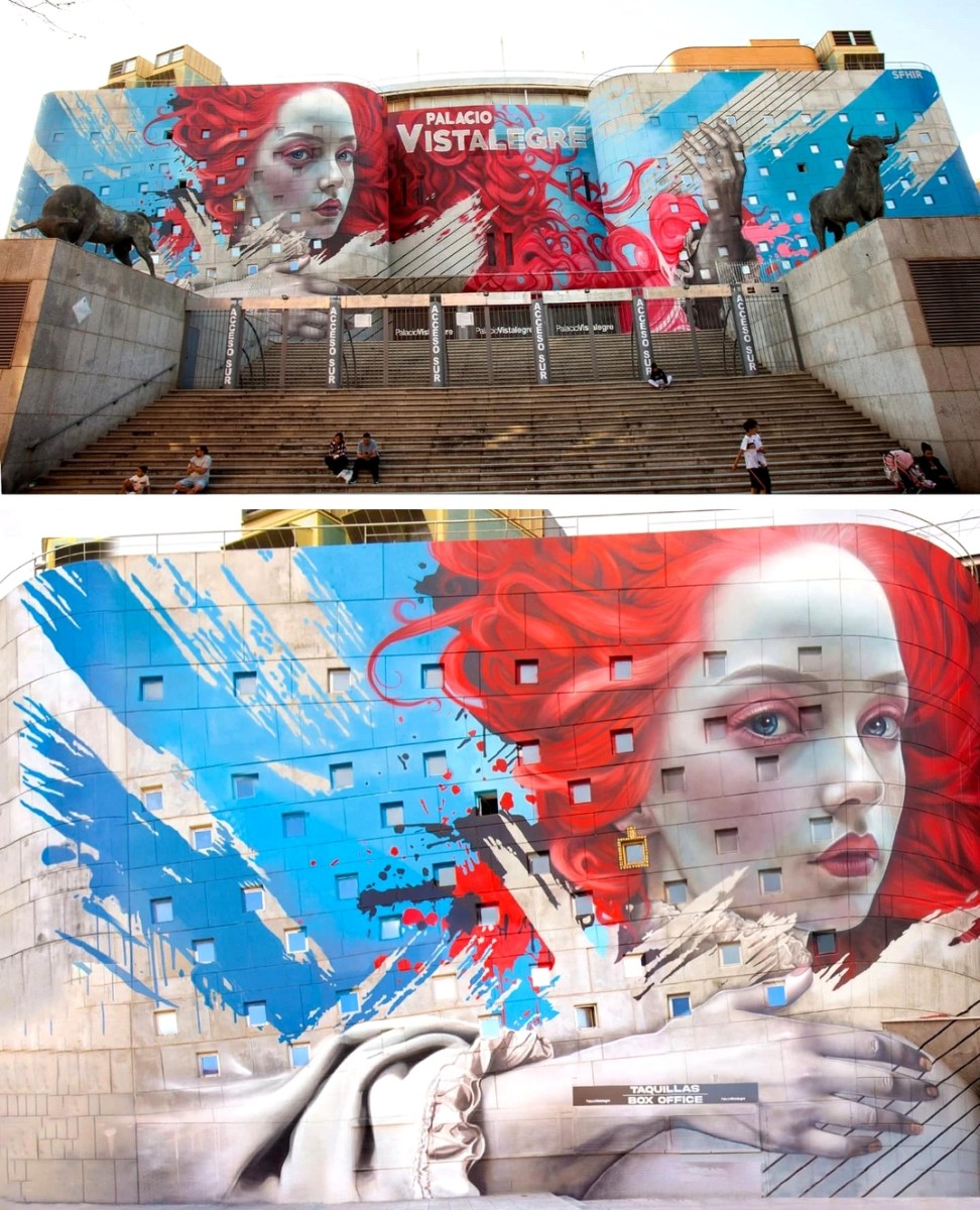 Mural by Sfhir in Madrid, Spain, showing a red-haired woman’s face with abstract splashes of blue and red behind her, spread across the curved architecture of the Palacio Vistalegre.