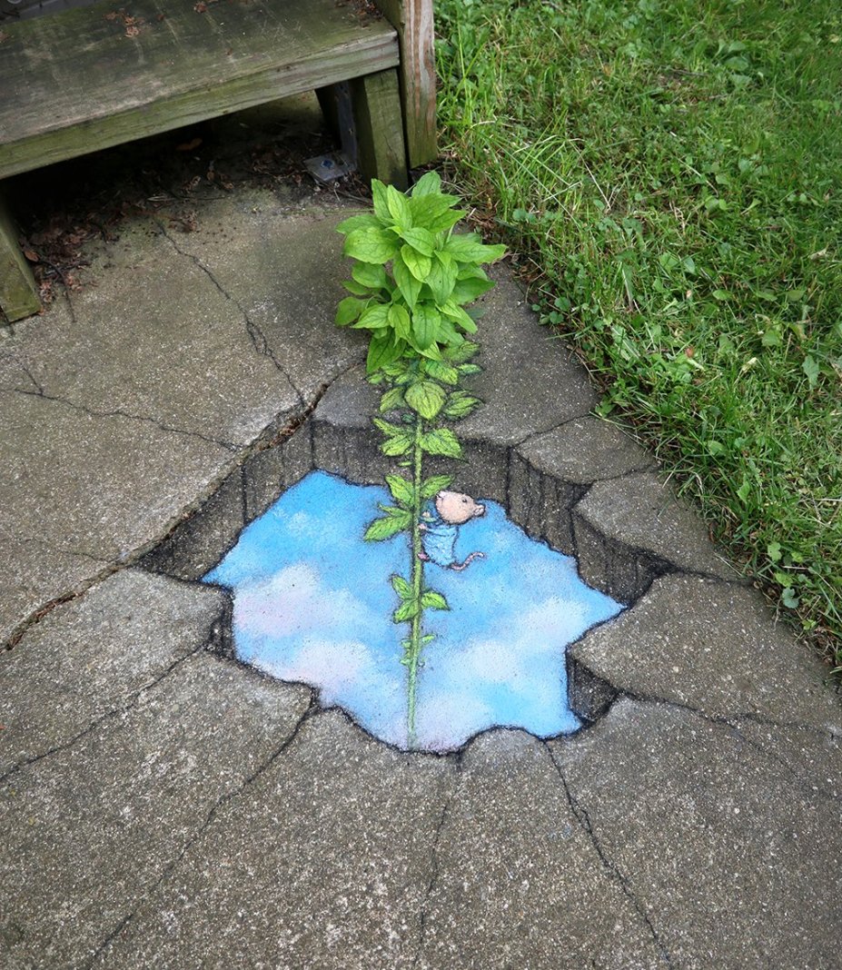 David Zinn chalk art in Ann Arbor showing a tiny mouse climbing a green plant that grows from a crack in the pavement above a painted blue underground space.