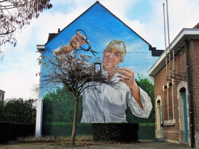 Clever street art by SMOK in Antwerp, Belgium, titled The Fake Gardener, where a mural interacts with a real tree.