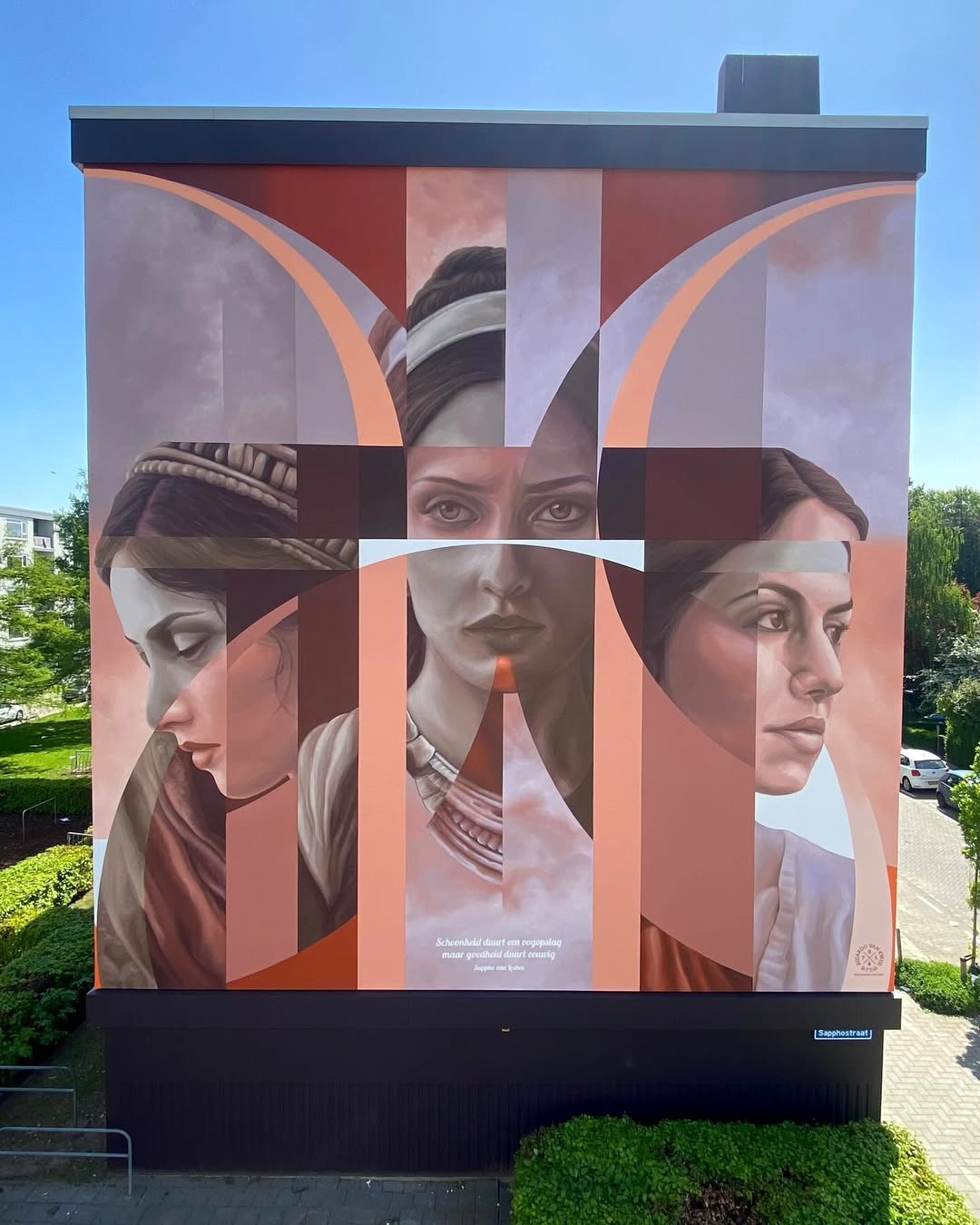 Mural titled “Sappho” in Rotterdam by Ricardo Van Zwol featuring four photorealistic female faces layered with abstract red and peach geometric bands across a building facade.