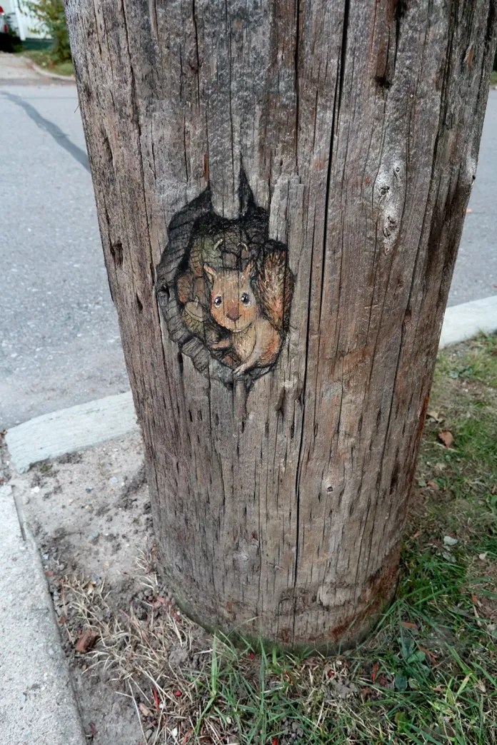 Small chalk art of a squirrel on a wooden pole